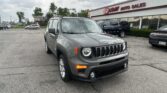 Grey Jeep SUV in foreground at a car dealership lot with EZ Loan Auto Sales sign in the background