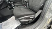 Interior of a car with front driver and passenger seats in black cloth, plus center console, gear shifter, and floor mat visible.