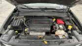 Open car hood revealing engine bay; engine cover reads '2.4L Multiair' with battery on the right, yellow oil cap, and the Jeep-style seven-slot grille visible at the front.