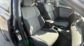 Front and rear seats visible in a parked car with gray fabric upholstery and center console, door open on the driver side.