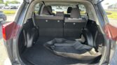 Open SUV hatch showing a spacious cargo area with third-row seats upright and black carpeting.