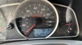Close-up of a car dashboard with a large speedometer (0–140 mph) and a digital display showing outside temperature 63°F and 94,513 miles on the odometer; red warning icons are visible on the gauge cluster