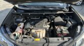 Open car hood revealing the engine bay with battery, coolant reservoir, and various hoses and components