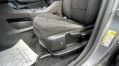 Interior of a car showing the front area: center console, armrest, and patterned driver/passenger seat with visible seatbelt buckle nearby