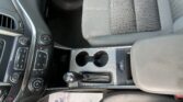 Center console of a car interior with gear shift, cup holders, and control panel visible between seats.