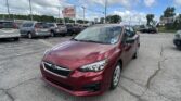 Maroon sedan in a busy parking lot with other vehicles and a roadside sign reading EZ LOAN Auto Sales in the distance.