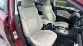 Beige fabric front seats in a red car, with the center console and steering wheel visible inside.