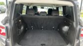 Open rear cargo area of a dark SUV with the back seats upright and ample trunk space visible