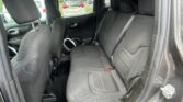 Back seat of a black fabric SUV interior with three headrests and seat belts visible, window to the outside on the left.