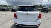 Rear view of a white Chevrolet SUV (Traverse) parked in a lot with other cars and dark stormy clouds overhead.]","Back of a white Chevy SUV in a dealership lot under a cloudy sky with many cars nearby.","White Chevrolet SUV from the rear in a crowded parking lot; ominous storm clouds in the sky.","Chevrolet Traverse SUV seen from the back in a parking lot, with multiple vehicles and overcast weather."]} }``` Wait formatting: The JSON must be proper without stray backticks. I produced with stray bracket. Let's fix. Provide array of strings properly. Also ensure no stray quotes. Let's output as enterprise: {