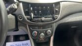 Interior of a car dashboard with a touchscreen infotainment system showing apps (Audio, Phone, Settings) and climate controls below.