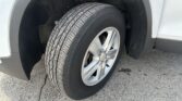 Close-up of a car's front wheel and tire, showing the alloy rim and surrounding wheel well.