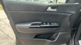 Black car door panel interior with silver door handle, speaker grille, and window control buttons visible on the armrest area
