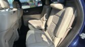 Interior of a blue SUV showing beige leather rear captain seats and headrests, view from open rear passenger door