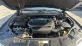 Open car hood revealing the engine bay with a V6 engine and surrounding components.