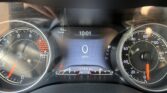 Close-up of a car dashboard: tachometer on left, speedometer on right, center digital readout shows 10:01 and 93 mi range (odometer 127,406 mi). The gear indicator shows P/R/N/D.