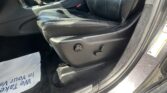 Black leather car interior focusing on the driver’s seat side with power-adjustment controls and the center console nearby.