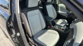 Open car door reveals the front seating area with two-tone gray seats and center console.
