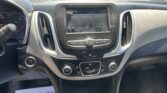 Center console and touchscreen showing a driving warning screen, viewed from the driver’s seat in a parked car