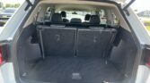 Rear cargo area of an SUV with the third-row seats upright and the hatch open.