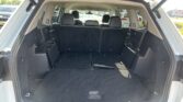 Rear cargo area of an SUV with the third-row seats folded down and black carpeting visible
