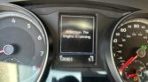 Car dashboard with central alert screen reading 'Attention: The engine is running,' flanked by the speedometer and tachometer.