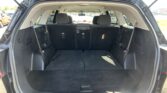 Open SUV trunk with rear seats folded flat to maximize cargo space in a black interior cargo area.
