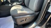Interior of a car showing the driver's area with a center console, gear shifter, and front seat edge/armrest visible.
