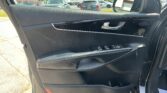 Driver-side car door interior with window controls, chrome handle, and side mirror visible; parking lot outside.