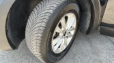 Close-up of a car tire and alloy wheel in the wheel well, showing tread pattern and tire branding.
