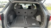 Open SUV trunk showing cargo area with rear seats upright and floor mats laid in the space