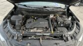 Open-hood view of a car engine bay showing ECOTEC engine, battery, coolant reservoir, and air intake components.