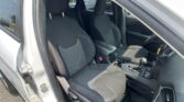 Open-driver-side view of a car interior with two black fabric front seats and center console visible.