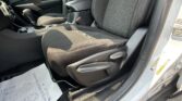 Front interior of a car showing black fabric seats, center console, and gear shifter between the driver and passenger seats.