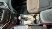 Interior of a car showing the center console with gear shifter, climate controls, and cup holders near the front seats
