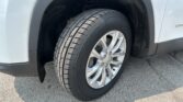Close-up of a car wheel and tire in the front wheel well, showing the tread and alloy rim.