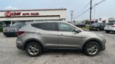 Silver SUV in the foreground at an auto dealership, with the E-Z Loan Auto Sales sign on the building and other cars in the lot behind it.