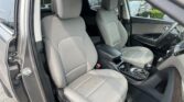 Interior of a right-hand-drive car with two gray fabric front seats, headrests, and a center console with cupholders visible