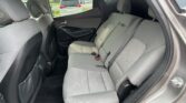 Rear interior of a modern SUV showing the back seat with grey fabric upholstery and seat belts fastened.