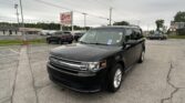 Black SUV in a dealership parking lot with an EZ LOAN Auto Sales sign in the background on an overcast day.