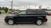Black SUV parked in a dealership lot with power lines and a Lion Auto Sales sign in the background.