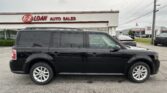Black SUV in the foreground at an auto dealership lot with the E-Z Loan Auto Sales sign on the building behind it.