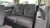 Interior view of a black SUV showing the rear passenger seats upright and a cup holder on the right side, with cargo space behind them.