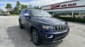 Dark blue Jeep SUV in a parking lot with an E-Z Loan Auto Sales storefront in the background.