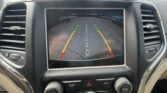 Rearview camera display showing parking guidance lines: green, yellow, red zones with a center dashed line and 'Check Entire Surroundings' text.