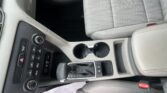 Interior view of a car's front center console: gear shift, cup holders, and climate control area in gray tones