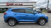Blue SUV parked in front of the EZ Loan Auto Sales showroom, with other cars and a cloudy sky in the background.