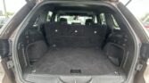 Open SUV trunk with rear seats upright and empty cargo area visible in a parking lot