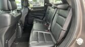 Backseat of a dark leather SUV interior with three seats and headrests visible