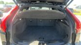 Open car trunk with cargo cover extended, showing spacious rear storage area in a red SUV under daylight.